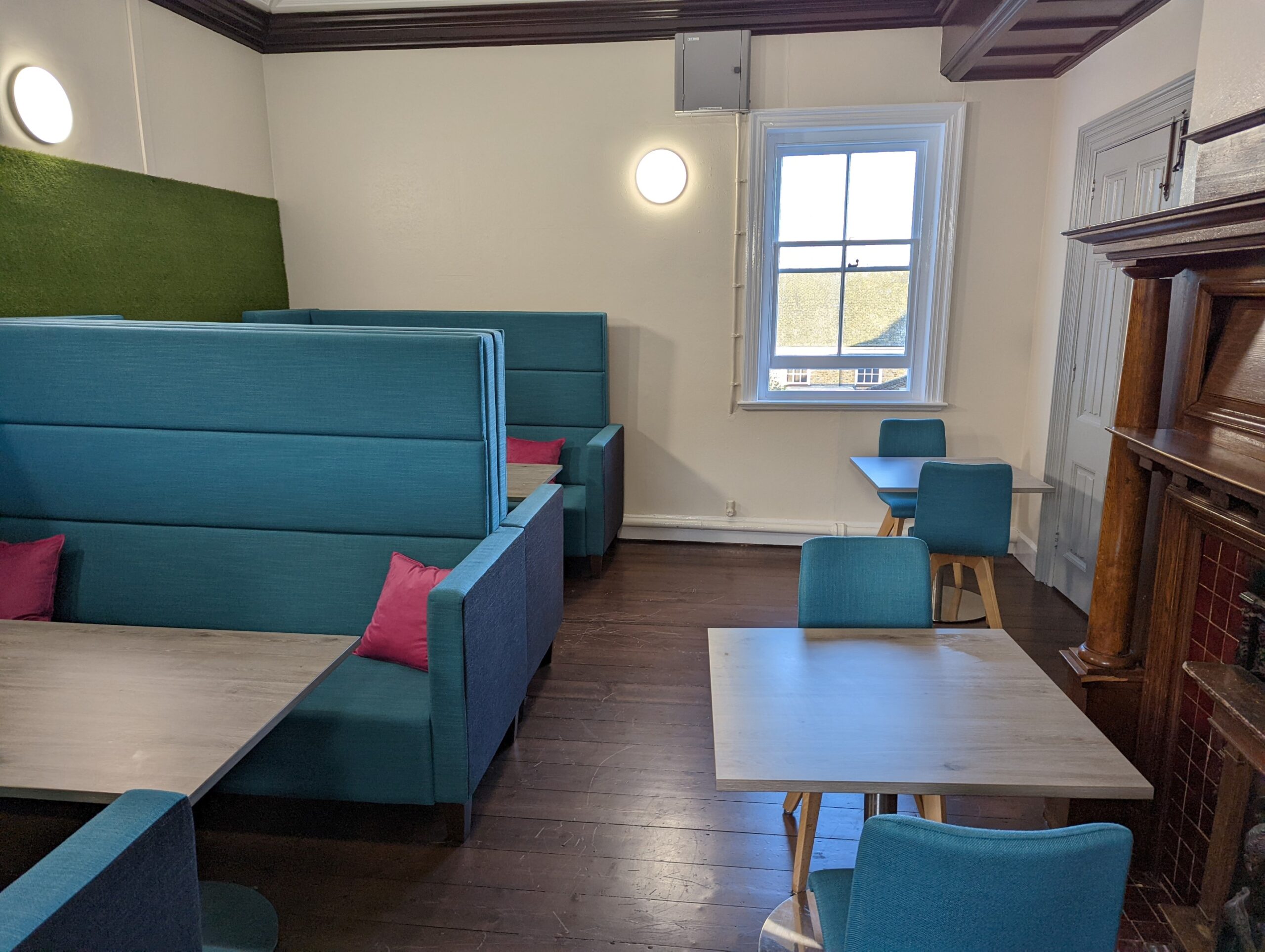 Student study room with blue booths and blue chairs at wooden tables