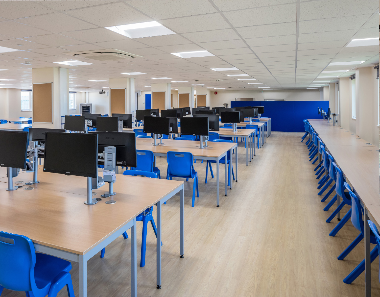 Student computer room with blue Postura chairs and fully welded tables